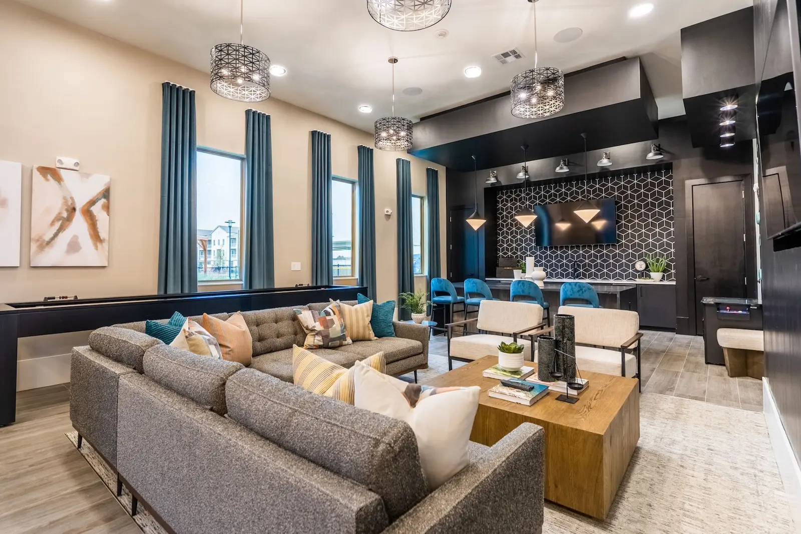Social clubroom with lush seating, a kitchen, and a television at our apartments in Cypress.