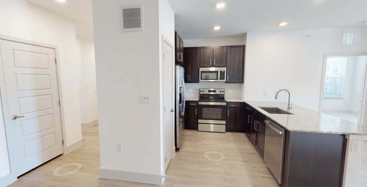 Kitchen with designer wood-style plank flooring at our apartments for rent in Cypress. Residences